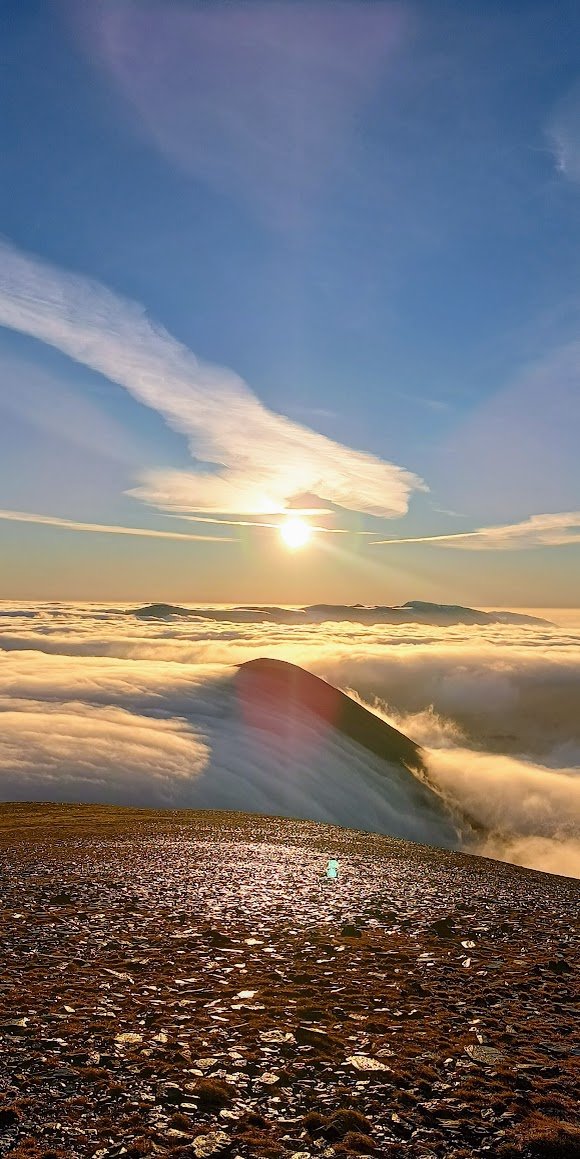 Sunlight above a sea of cloud flowing over a ridge below Skiddaw, photographed by Joss