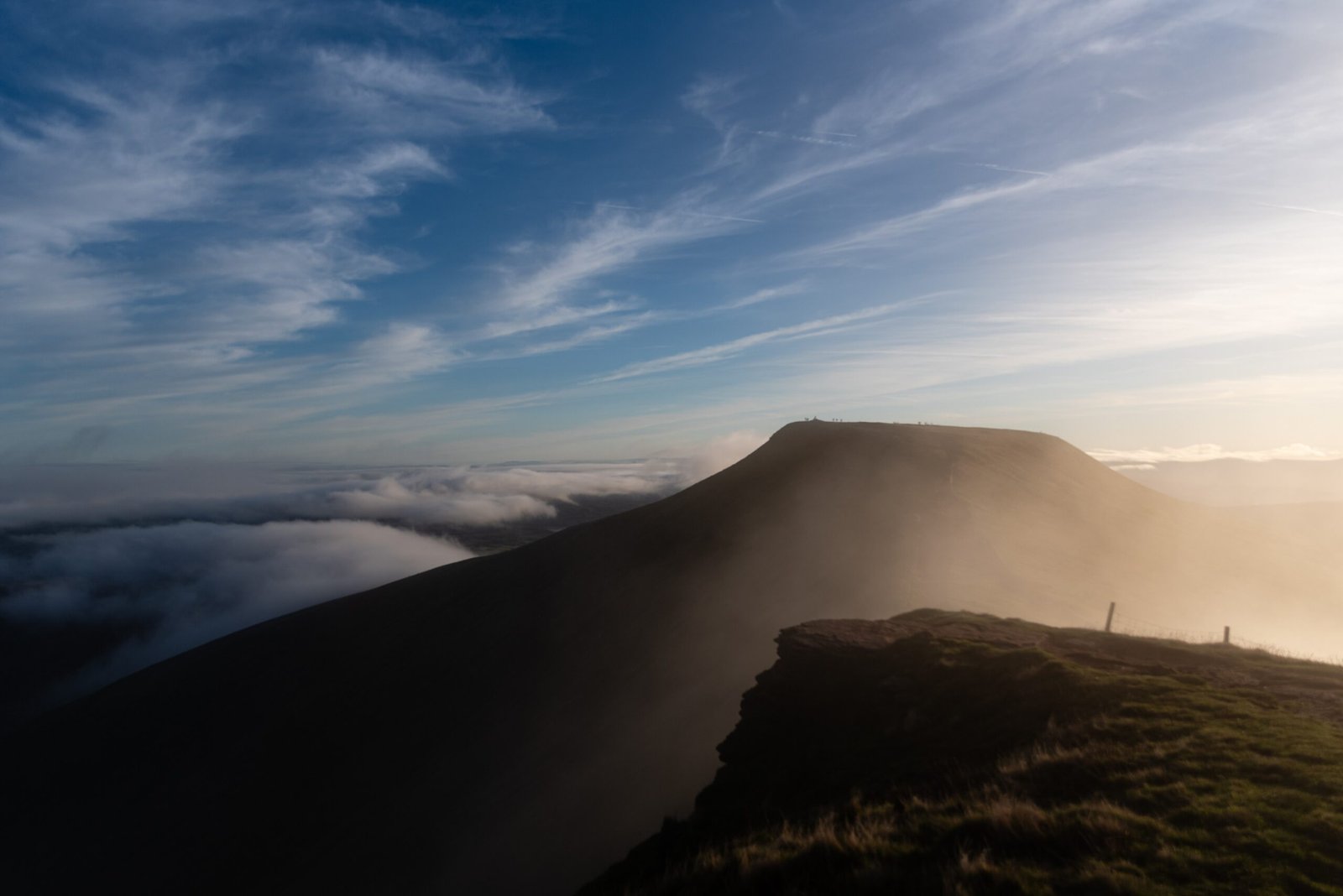Sunlight catching a flat-topped mountain above cloud-filled valleys in Bannau Brycheiniog